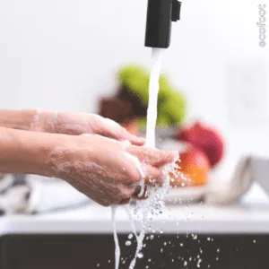 hands washing under a kitchen tap with running water