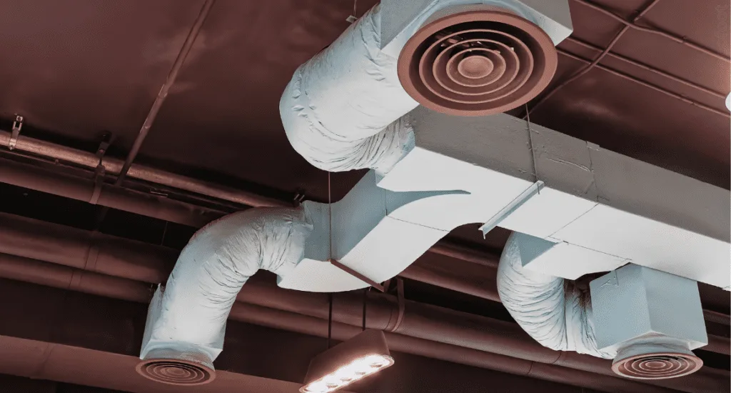 Ceiling-mounted ducted air conditioning vents in a commercial building, showing a ducted reverse cycle system used for heating and cooling.