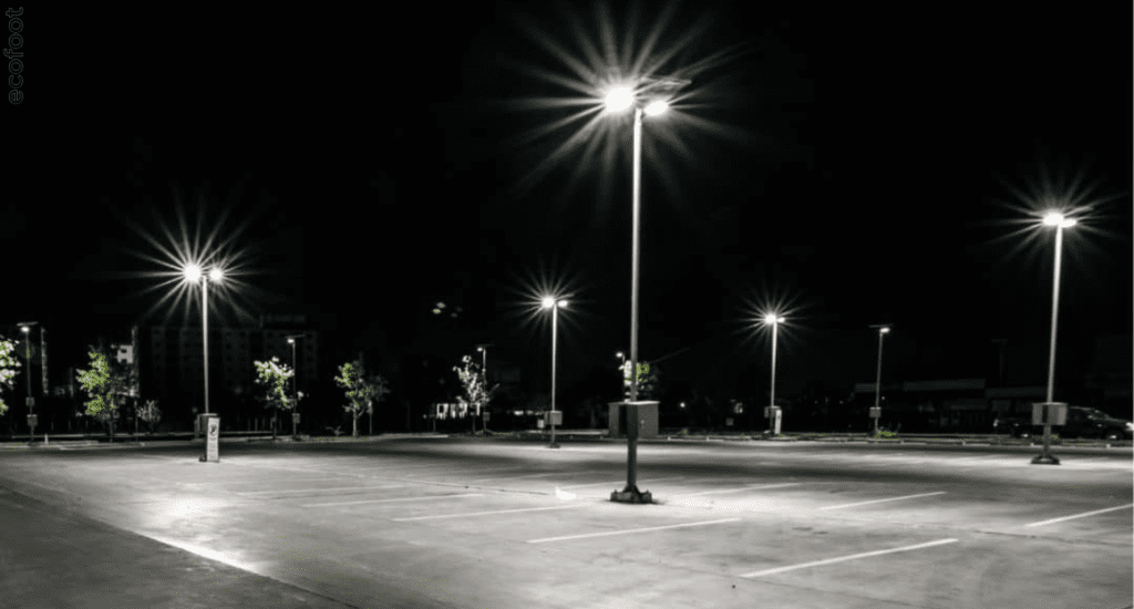 Bright LED flood lights illuminating an empty parking lot at night, showcasing energy-efficient lighting upgrades