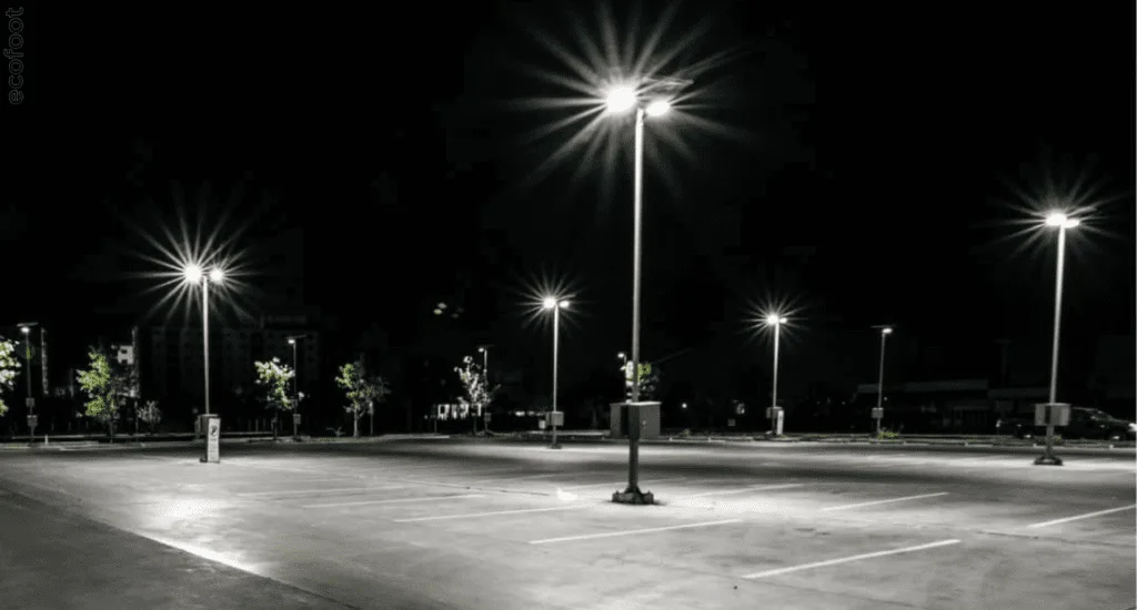 Bright LED flood lights illuminating an empty parking lot at night, showcasing energy-efficient lighting upgrades