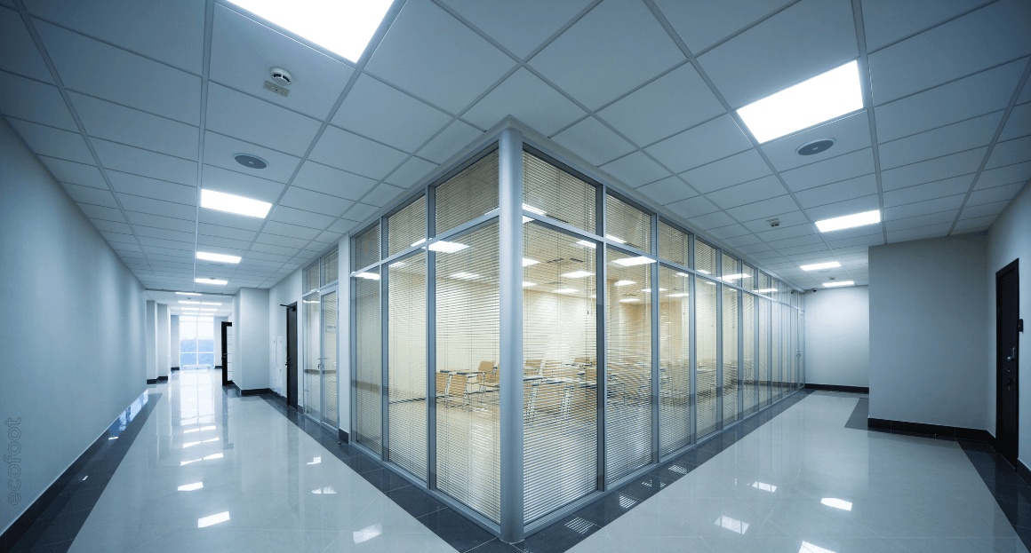 Modern office corridor illuminated with energy-efficient LED lighting fixtures after upgrade, showcasing bright and uniform lighting performance.