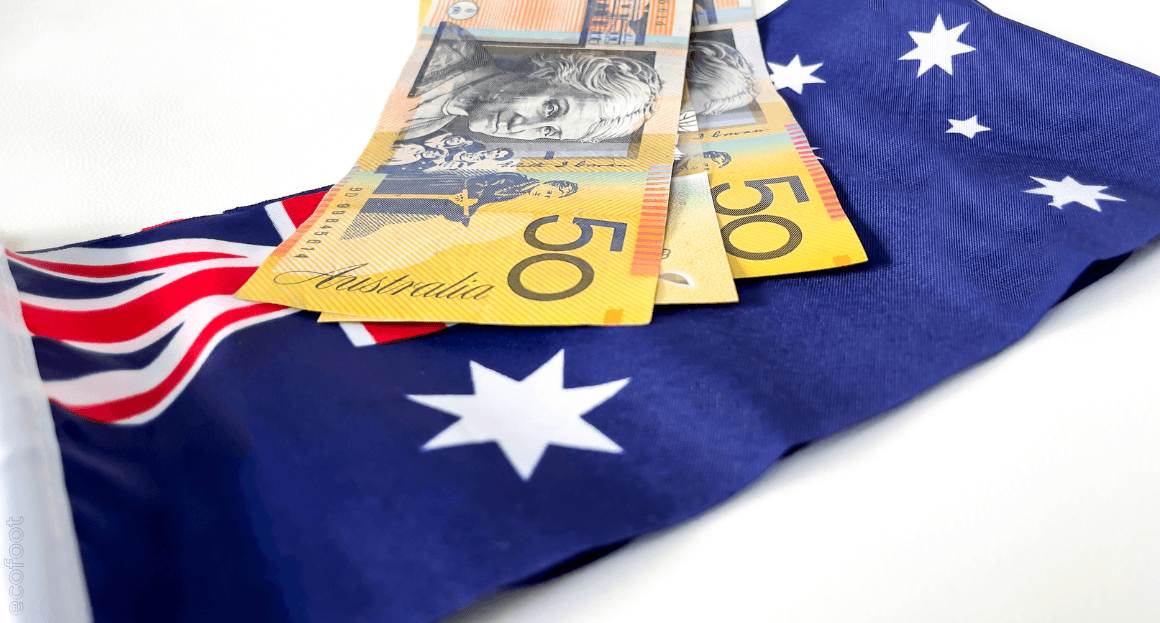 Australian flag with Australian dollar notes placed on top, representing energy-efficiency rebates and cost savings on home cooling systems. 