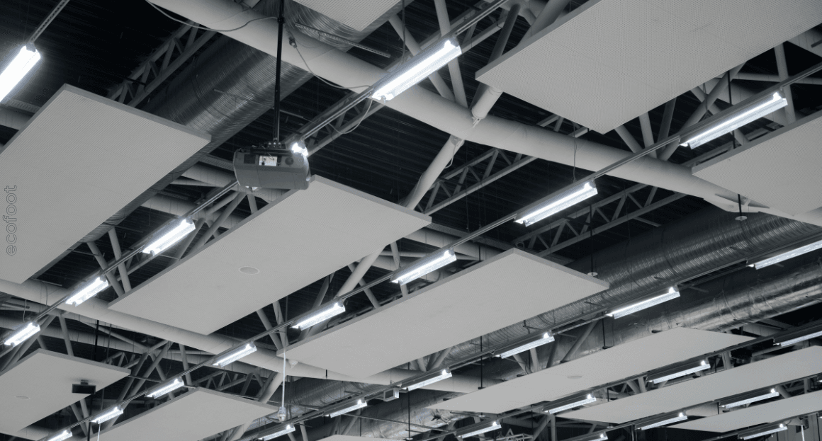 LED lighting installed on an industrial ceiling with metal framework and acoustic panels.