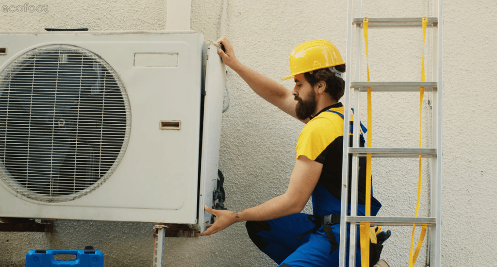 Technician installing an outdoor reverse-cycle air conditioner unit on a residential wall in Victoria.