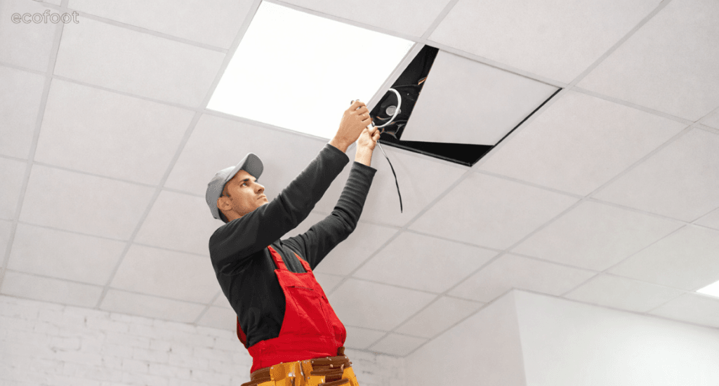 Electrician installing LED ceiling lights in an aged care facility to improve safety, comfort, and energy efficiency.