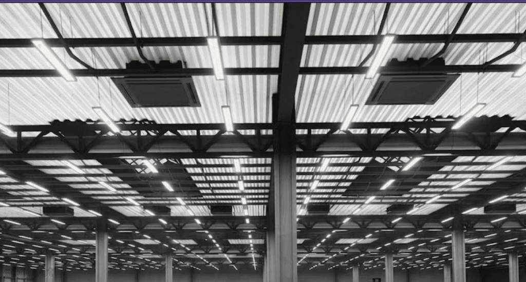 Commercial LED lighting installed in industrial warehouse ceiling improving energy efficiency and visibility.
